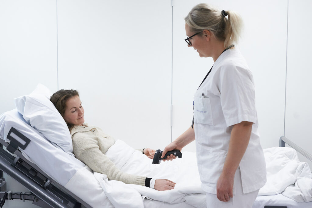 En sykepleier skanner pasientens armbånd